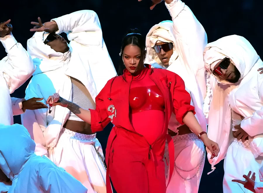 Rihanna completes dance steps with her ensemble surrounding her.