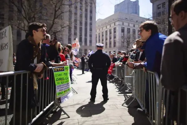 Demonstrators of both sides separated by a line of police officers.